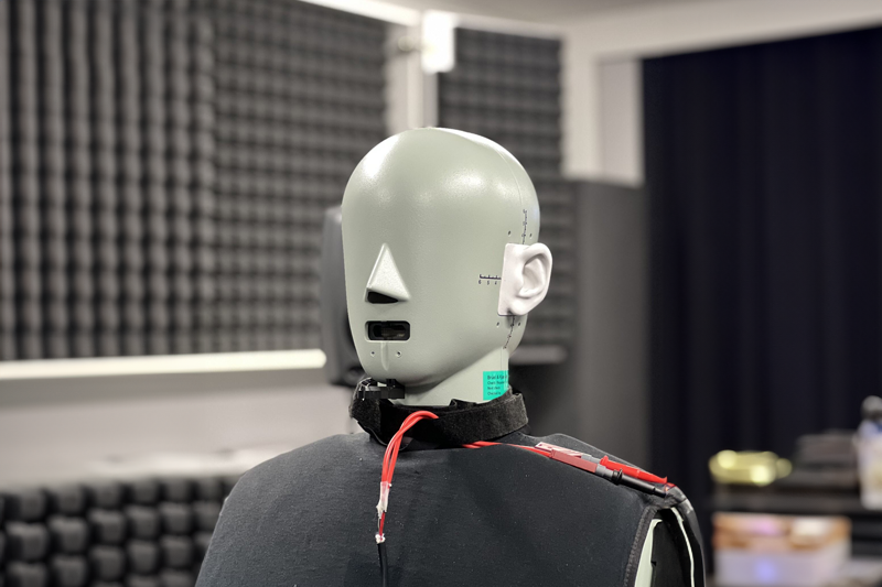 Head and torso simulator in the listening room, acoustic absorber panels behind it